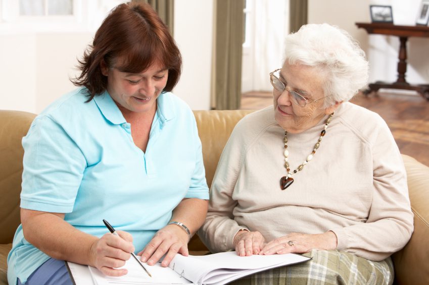 Caregiver assisting elderly woman with paperwork