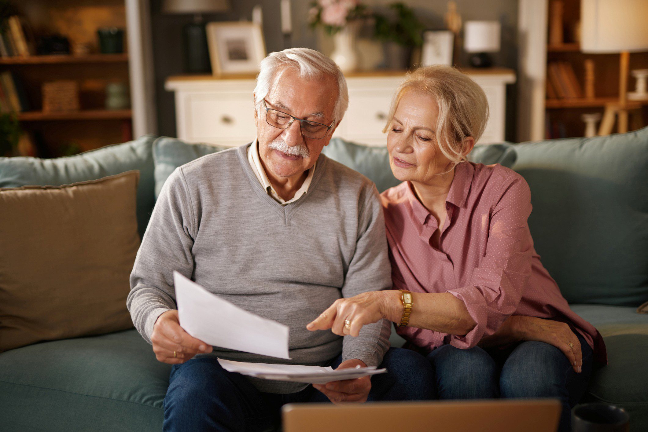 Elderly pair discussing paperwork at home